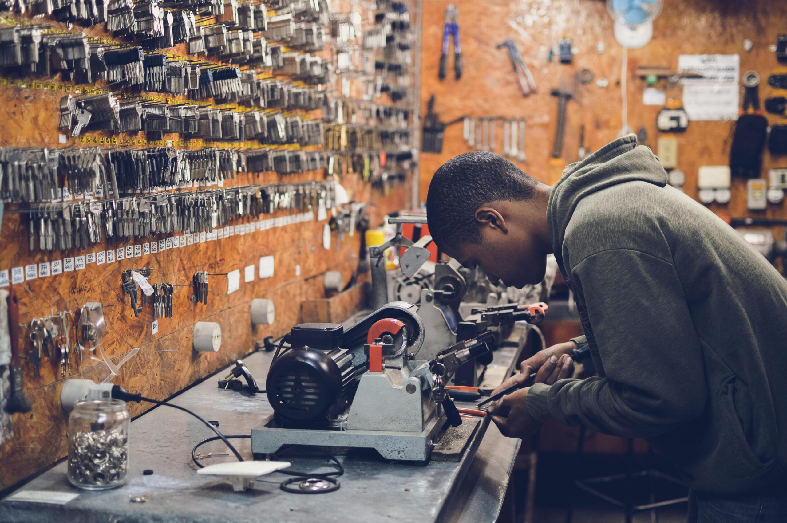 Man in Grey Hoodie Jacket Holding Black Metal Near White Socket Power Supply